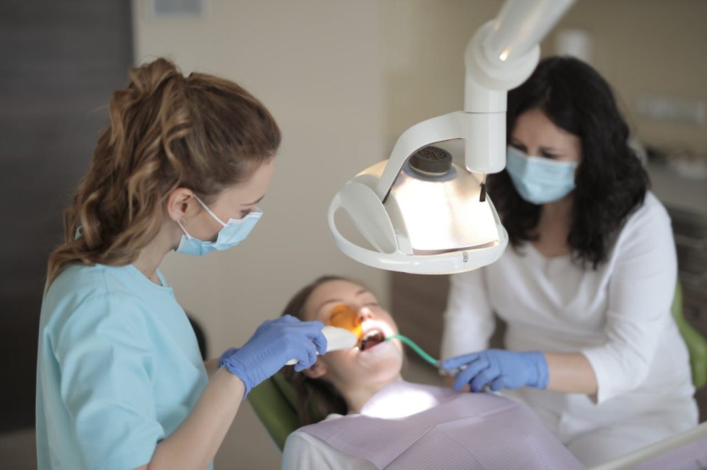 Professional dental care procedure with dentists in a clinic setting.